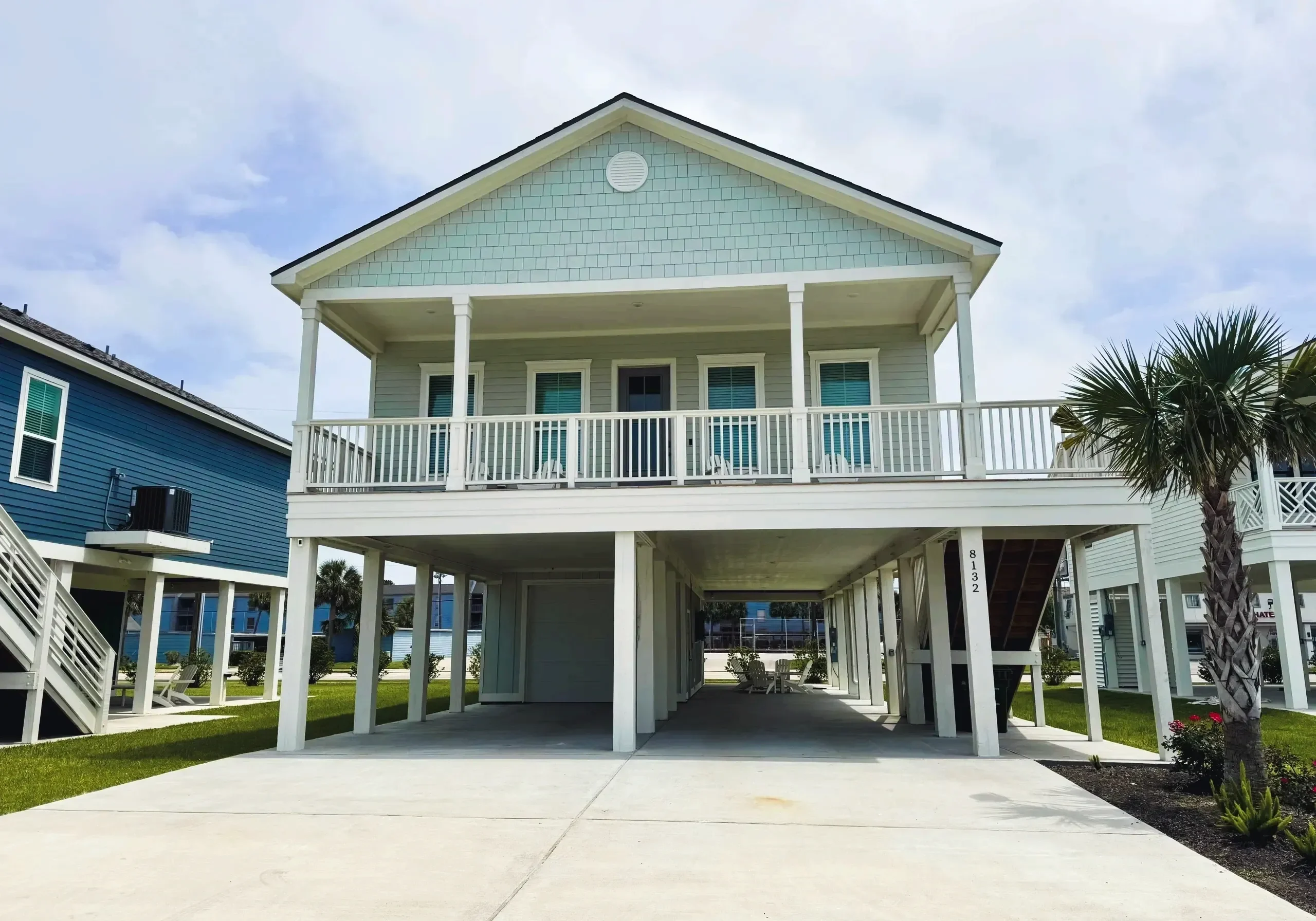 Elevated beach house with blue exterior.