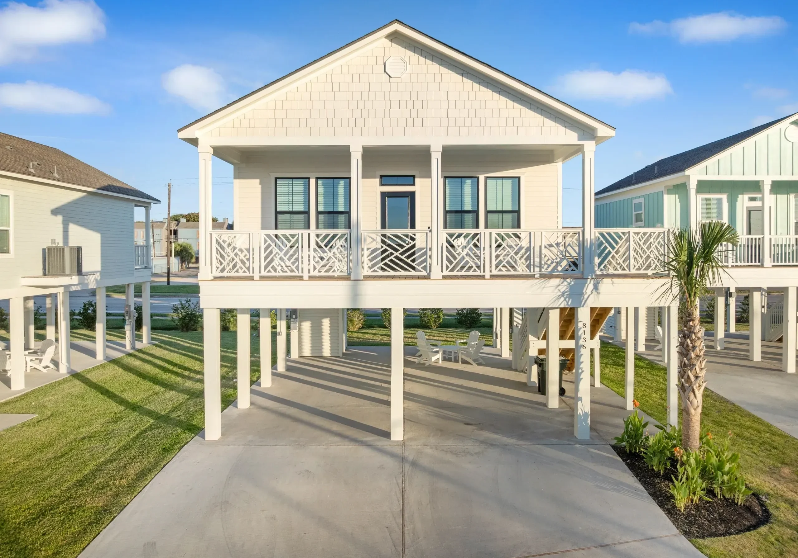 Elevated white house with sunny sky background.
